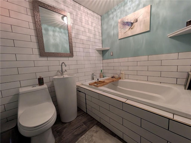 bathroom with a bath, tile walls, and toilet