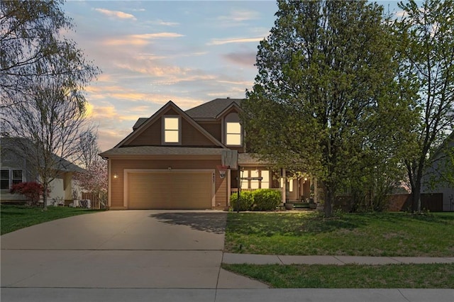 view of front of home featuring a lawn, driveway, and a garage