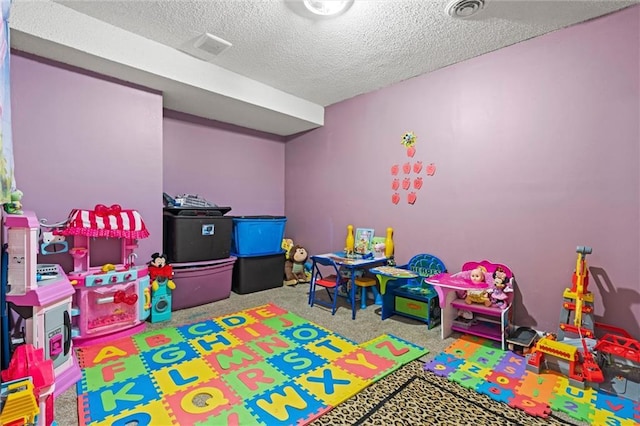 game room with carpet, a textured ceiling, and visible vents