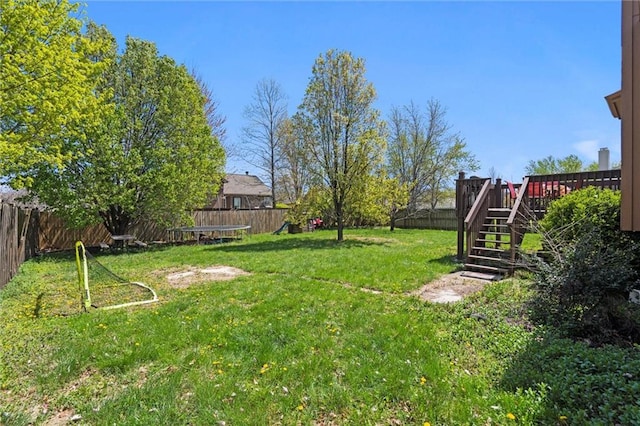 view of yard with a fenced backyard, a deck, and stairway