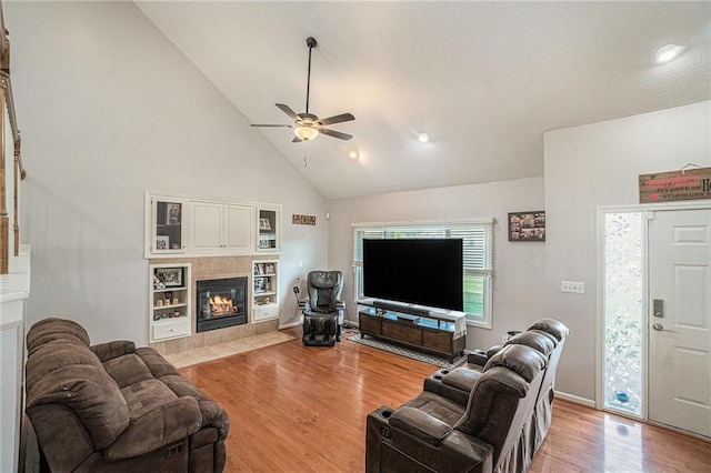 401 NW 51st St, Gladstone, MO 64118 - living area with a tiled fireplace, high vaulted ceiling, a ceiling fan, and light wood finished floors