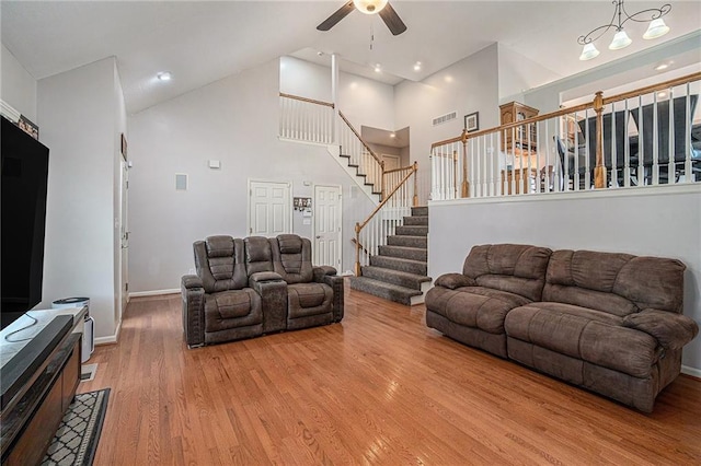 401 NW 51st St, Gladstone, MO 64118 - living area featuring a ceiling fan, light wood-style floors, stairs, high vaulted ceiling, and baseboards