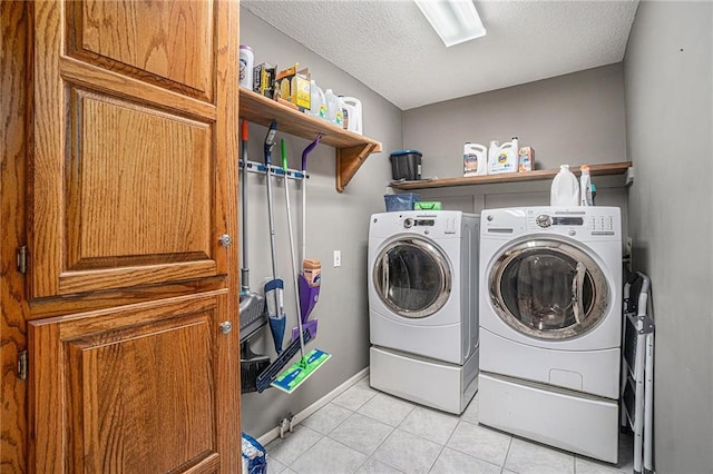 401 NW 51st St, Gladstone, MO 64118 - laundry room with washing machine and dryer, light tile patterned flooring, a textured ceiling, and baseboards