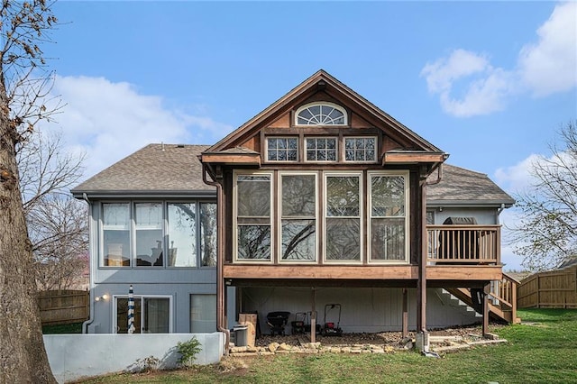 401 NW 51st St, Gladstone, MO 64118 - back of property with a sunroom, stairway, a shingled roof, and a deck