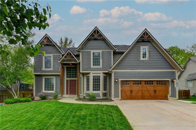 craftsman-style home with fence, driveway, a front lawn, and a garage