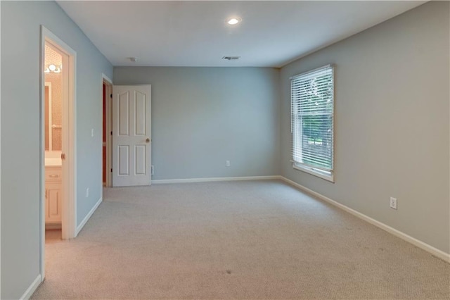 unfurnished room with baseboards, light colored carpet, recessed lighting, and visible vents