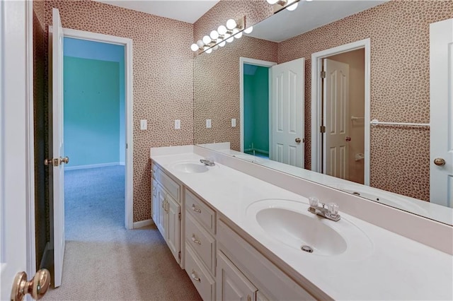 bathroom featuring double vanity, baseboards, and a sink