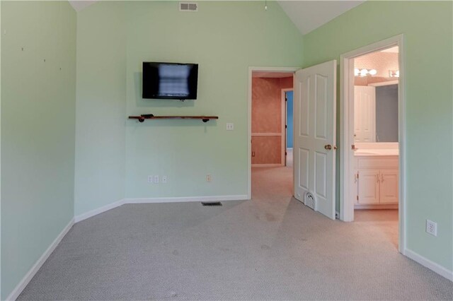 unfurnished bedroom featuring carpet flooring, baseboards, vaulted ceiling, and visible vents