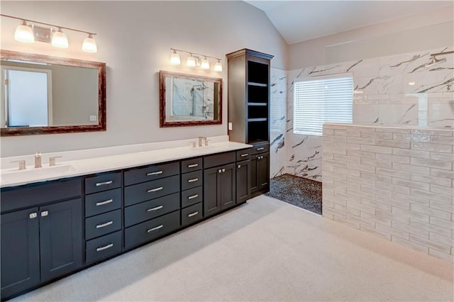 bathroom with double vanity, walk in shower, a sink, and lofted ceiling