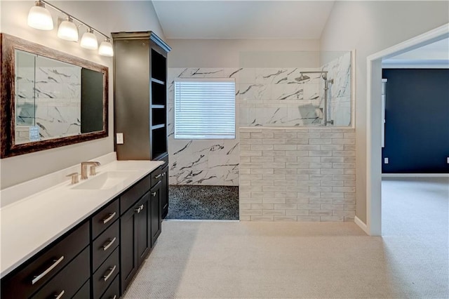 full bath with a marble finish shower and vanity