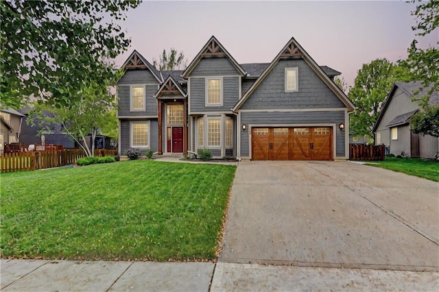 view of front facade featuring concrete driveway, fence, and a front lawn