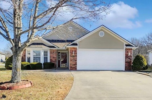 traditional home featuring brick siding, driveway, and an attached garage