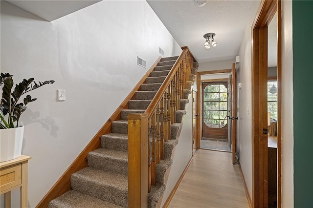 2102 W Dennis Ave, Olathe, KS 66061 - stairway with baseboards, visible vents, and wood finished floors