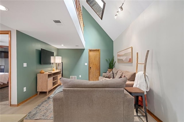 2102 W Dennis Ave, Olathe, KS 66061 - living area with light wood-style floors, baseboards, a skylight, and visible vents
