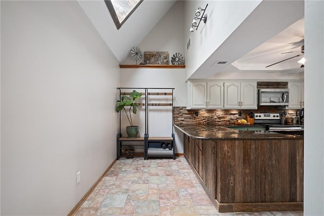 2102 W Dennis Ave, Olathe, KS 66061 - kitchen featuring white cabinets, stainless steel appliances, baseboards, a peninsula, and backsplash