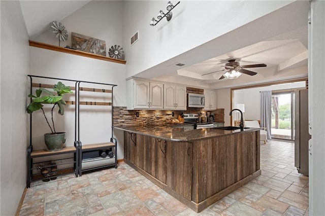 2102 W Dennis Ave, Olathe, KS 66061 - kitchen with visible vents, decorative backsplash, stone finish floor, a sink, and appliances with stainless steel finishes