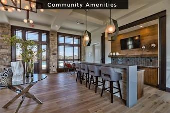 10300 W 174th St, Overland Park, KS 66221 - bar featuring wood finished floors, hanging light fixtures, a high ceiling, backsplash, and a chandelier