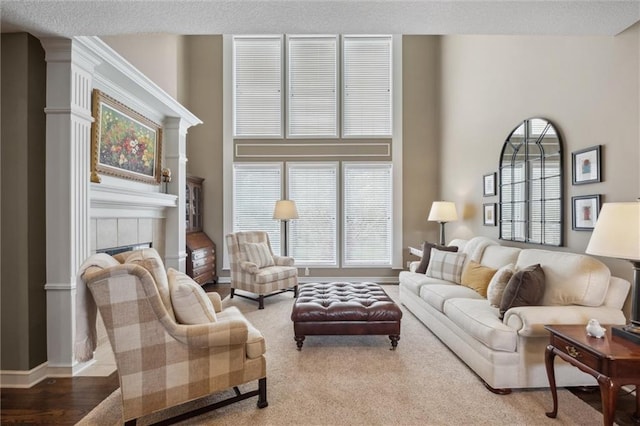 living room with baseboards, a tile fireplace, and wood finished floors
