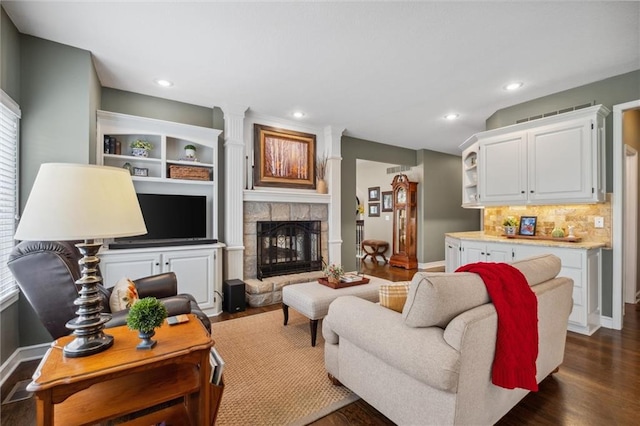 living area with recessed lighting, baseboards, dark wood-style floors, and a fireplace