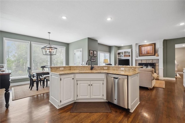 kitchen featuring a sink, a fireplace, dark wood-type flooring, and dishwasher