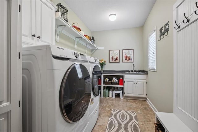 laundry room featuring cabinet space, a sink, separate washer and dryer, stone finish floor, and baseboards