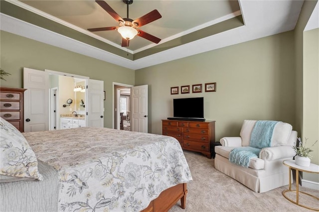 bedroom featuring crown molding, ceiling fan, light colored carpet, a raised ceiling, and ensuite bath