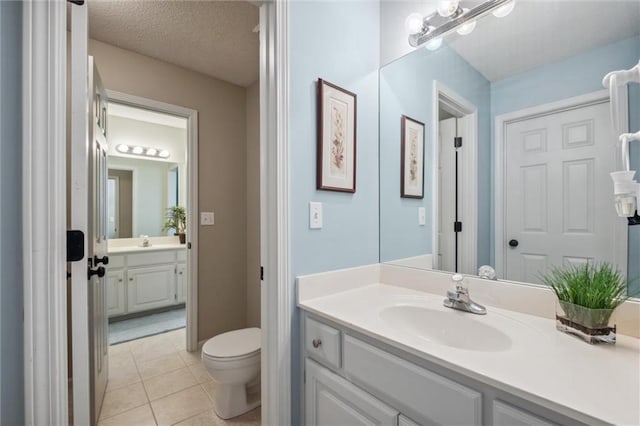 bathroom with vanity, tile patterned flooring, and toilet