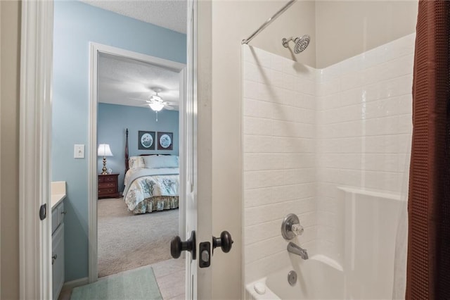 full bath featuring ensuite bath, vanity, a textured ceiling, a ceiling fan, and shower / bathing tub combination