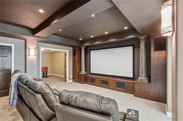 home theater room with baseboards, a textured ceiling, decorative columns, and light colored carpet