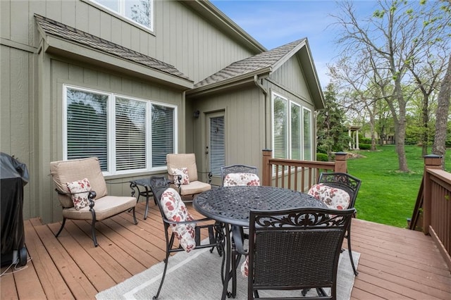 wooden terrace featuring a yard and outdoor dining space