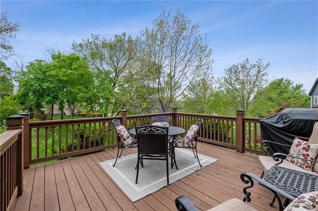 wooden deck with outdoor dining area and area for grilling