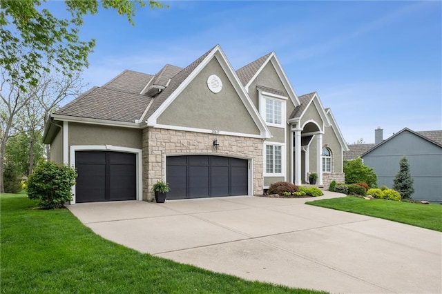 view of front of house with a garage, a front lawn, concrete driveway, stone siding, and stucco siding