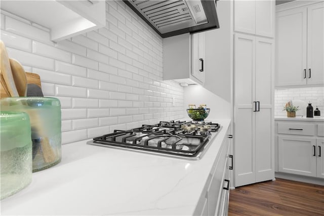 kitchen featuring white cabinetry, backsplash, exhaust hood, stainless steel gas cooktop, and dark wood finished floors