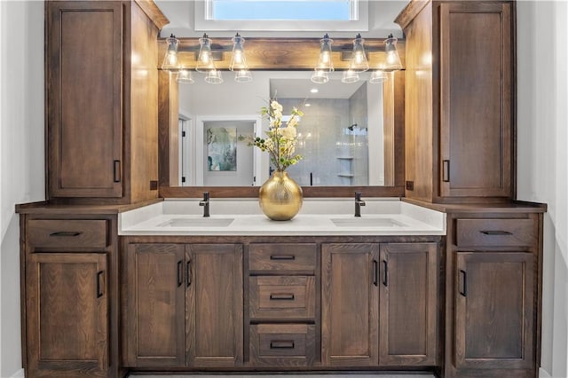 bathroom featuring double vanity, a sink, and walk in shower