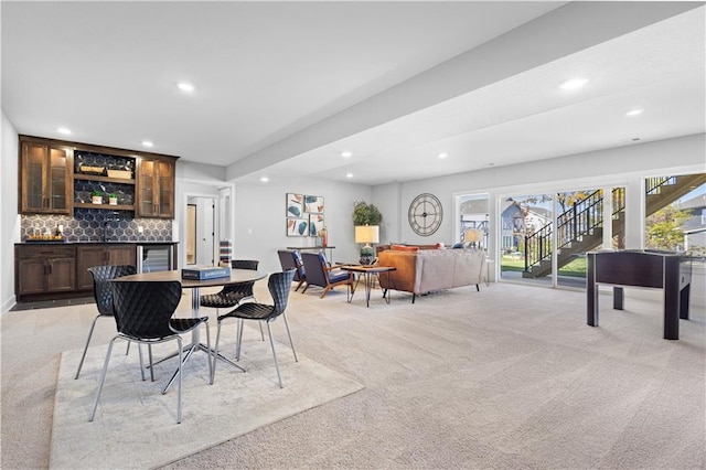 dining area featuring light carpet, recessed lighting, indoor bar, and wine cooler
