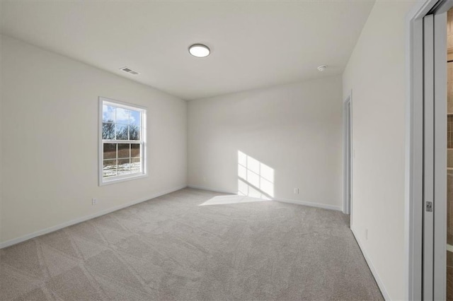 carpeted spare room featuring baseboards