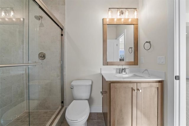 bathroom with a shower stall, toilet, vanity, and tile patterned flooring