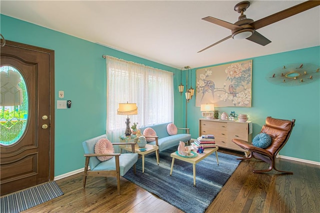 sitting room featuring baseboards, ceiling fan, and wood finished floors