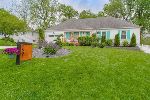 ranch-style house featuring a front lawn, roof with shingles, an attached garage, and fence