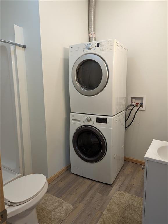 700 W 40th Hwy, Sweet Springs, MO 65351 - washroom with baseboards, light wood-type flooring, stacked washer / drying machine, and laundry area
