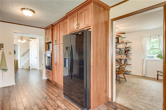 763 J Hwy, Peculiar, MO 64078 - kitchen with black appliances, ceiling fan, a textured ceiling, wood finished floors, and ornamental molding