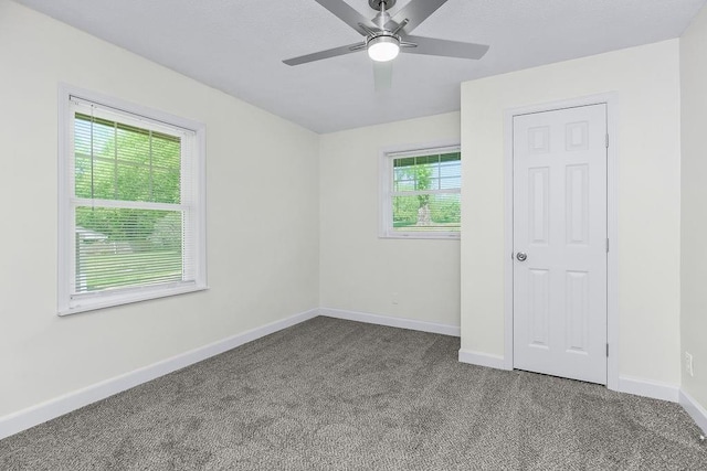 2308 NW 53rd Ter, Kansas City, MO 64151 - unfurnished room with dark colored carpet, baseboards, and ceiling fan