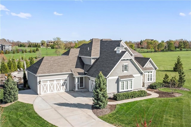 view of front of property featuring driveway, an attached garage, a shingled roof, and a front lawn
