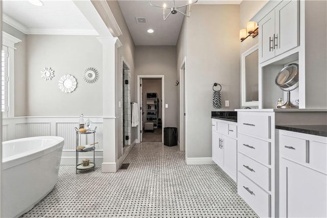 full bathroom with decorative columns, a shower stall, vanity, visible vents, and wainscoting