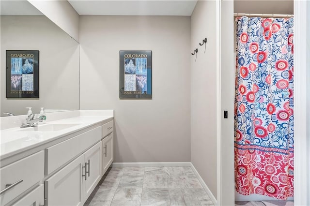 bathroom with vanity, baseboards, and curtained shower
