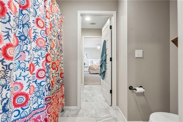 ensuite bathroom featuring a shower with shower curtain, baseboards, ensuite bathroom, toilet, and visible vents