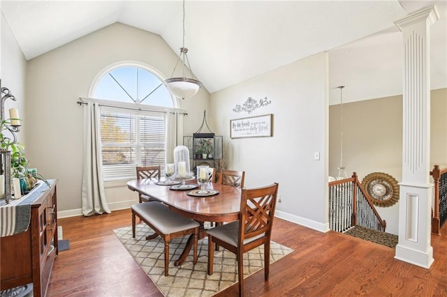 dining space featuring ornate columns, baseboards, lofted ceiling, and wood finished floors