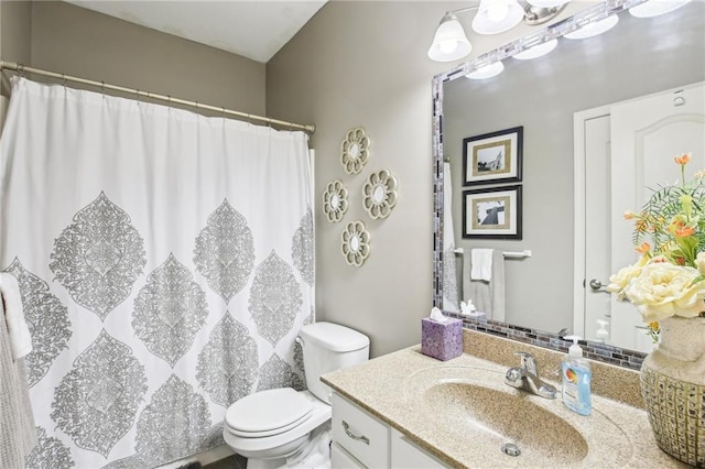 bathroom with toilet, curtained shower, and vanity