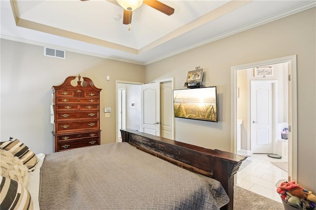 tiled bedroom with ornamental molding, a tray ceiling, ensuite bath, and visible vents