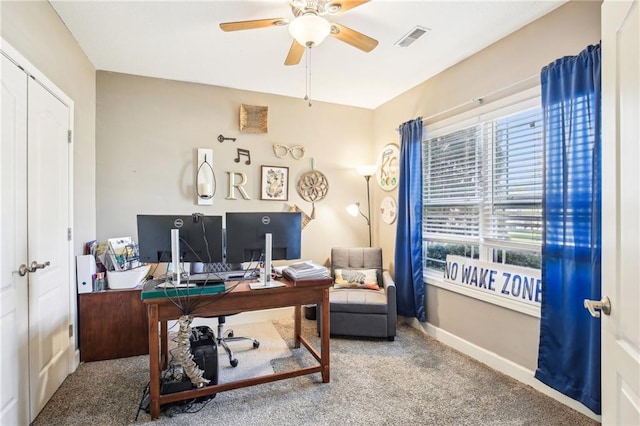 carpeted office space with visible vents, a ceiling fan, baseboards, and plenty of natural light